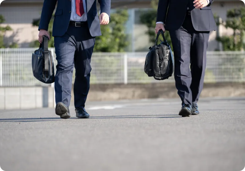 外を歩く2人の男性職員の足元