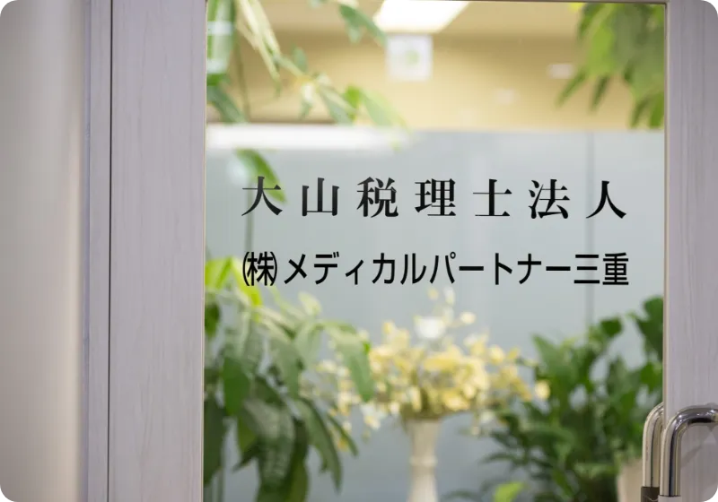 「大山税理士法人 (株)メディカルパートナー三重」と書かれたドアのガラス