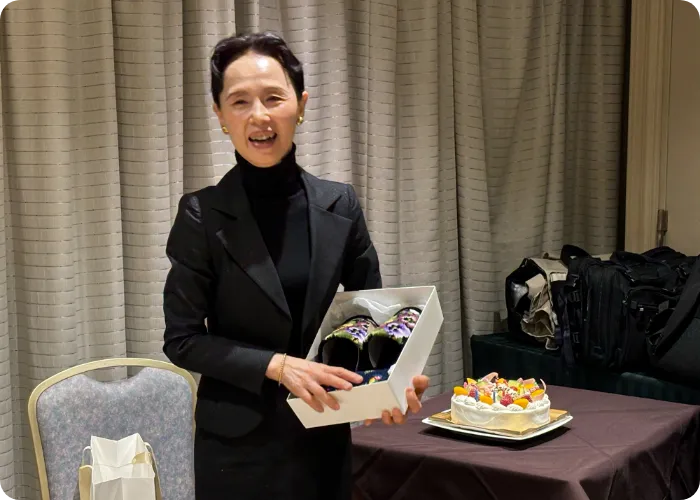 ケーキの前でギフトボックスを持つ女性