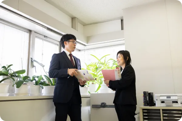 オフィスで立って話す男性職員と女性職員