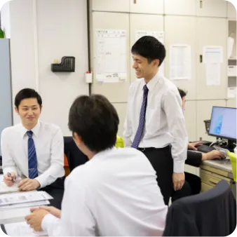 デスクで話し合う3人の男性職員