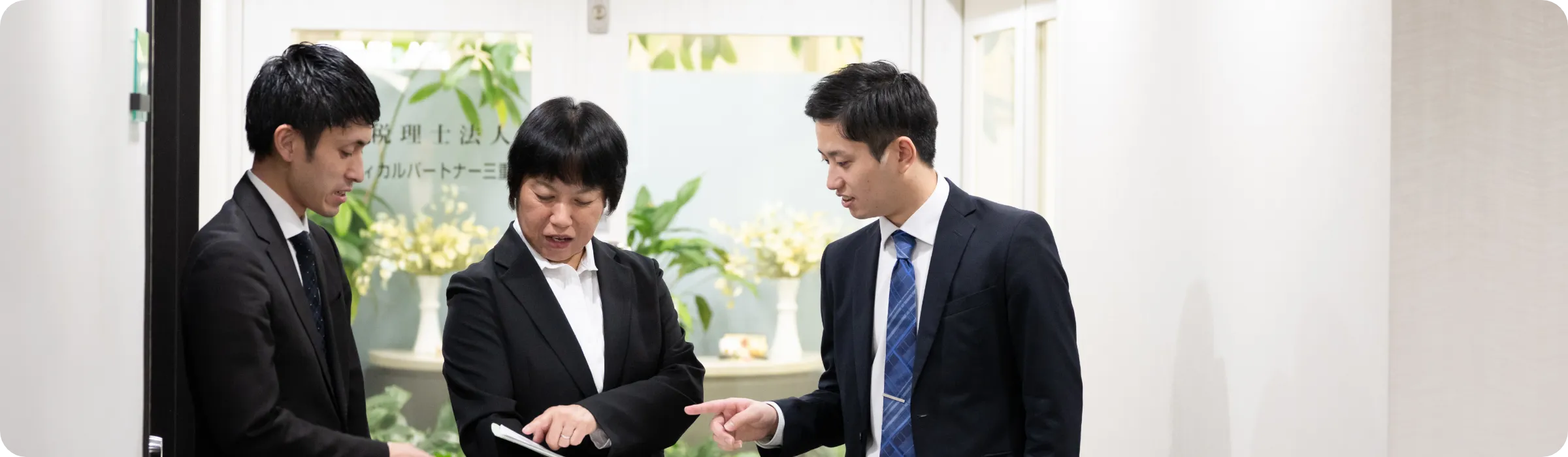 資料を見ながら話す女性職員と2人の男性職員