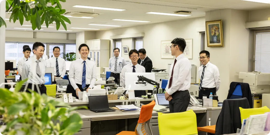 事務所内で起立する職員たちの様子