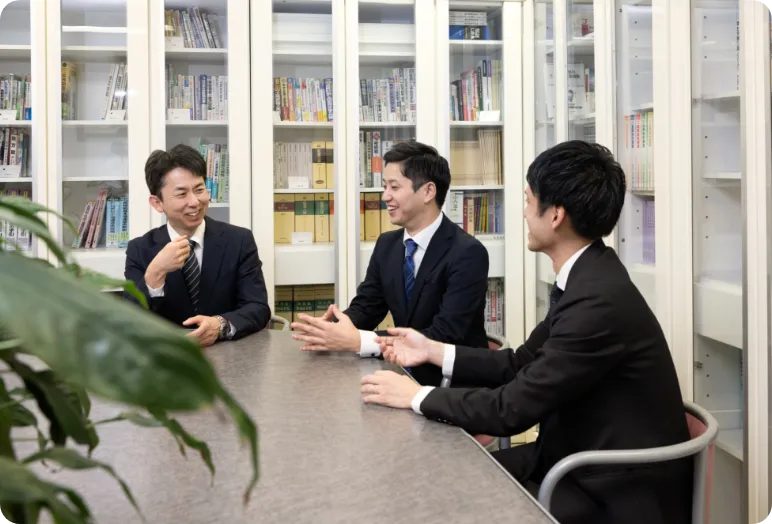 オフィスで話し合う3人の職員職員
