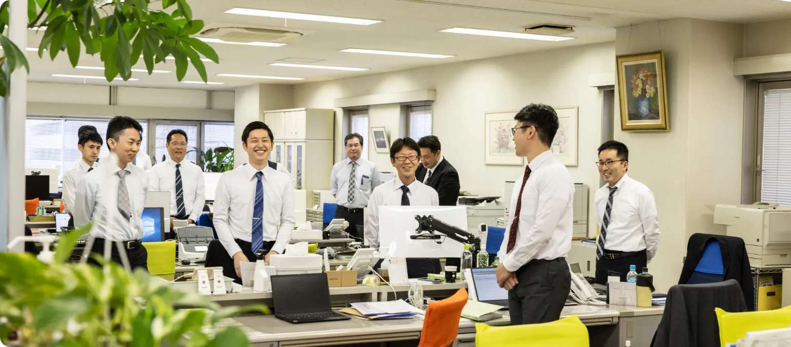 オフィスで起立する職員たちの様子